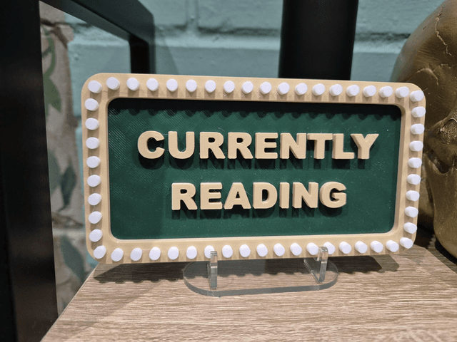 Currently Reading Sign with Stand by Merch — book cover